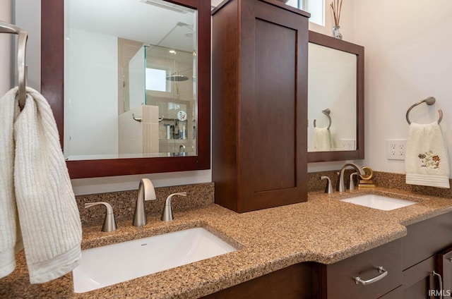 bathroom featuring a shower with door and vanity