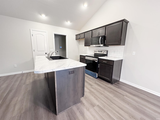 14812 Verona Lakes Psge, Fort Wayne, IN 46814 - kitchen featuring stainless steel range with electric cooktop, a sink, backsplash, light wood-type flooring, and a center island with sink