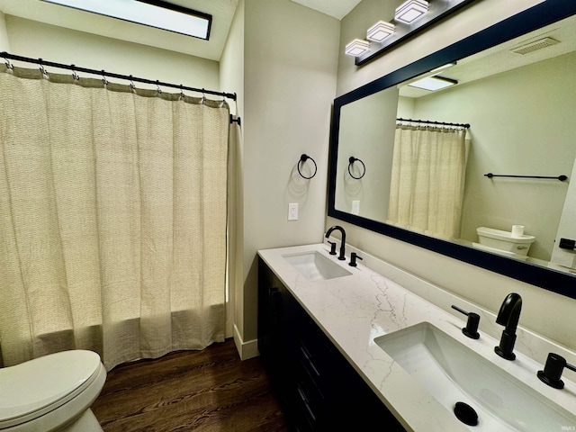 bathroom featuring vanity, hardwood / wood-style flooring, and toilet