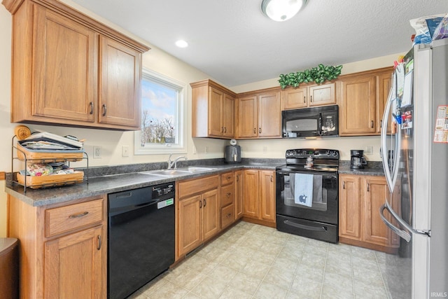 kitchen with sink, black appliances, and a textured ceiling