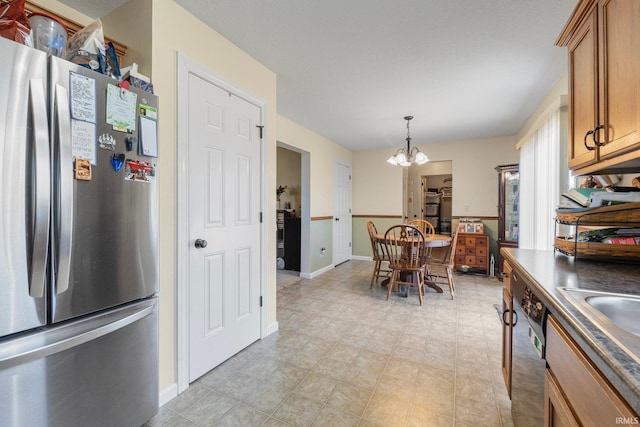 kitchen featuring pendant lighting, sink, stainless steel fridge, dishwasher, and a chandelier