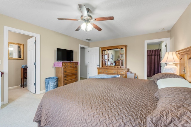 carpeted bedroom featuring ceiling fan and a textured ceiling