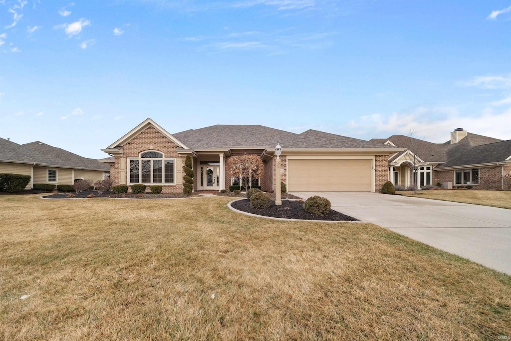 ranch-style house featuring a garage and a front yard