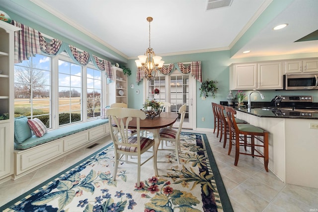 tiled dining room featuring ornamental molding, a chandelier, and sink