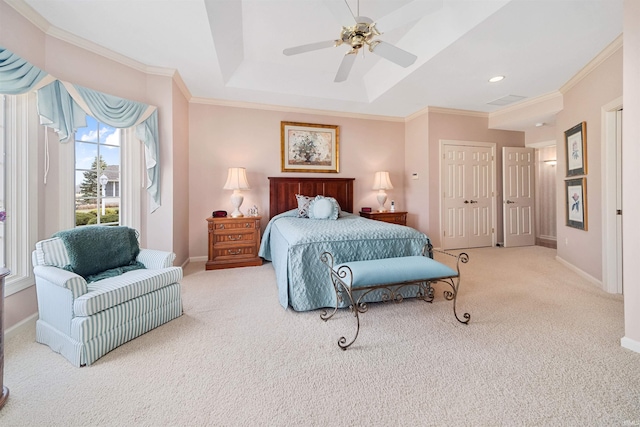 carpeted bedroom featuring ceiling fan, ornamental molding, and a raised ceiling