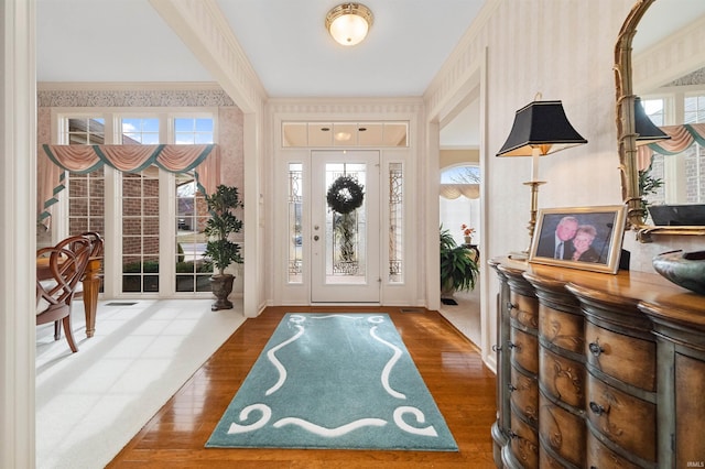 foyer entrance featuring hardwood / wood-style floors and crown molding