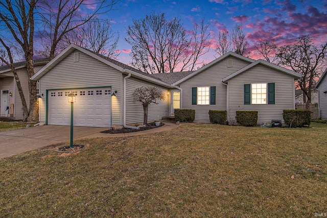 ranch-style house with a garage and a lawn