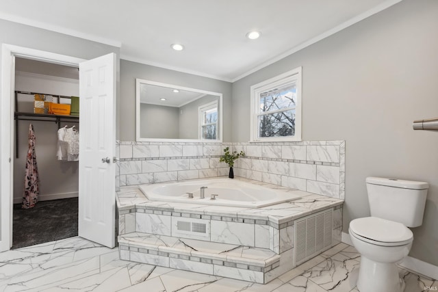 bathroom featuring a relaxing tiled tub, crown molding, and toilet