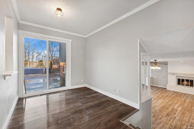 unfurnished dining area featuring ornamental molding, hardwood / wood-style floors, and a brick fireplace