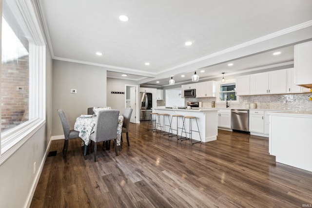 dining room with dark hardwood / wood-style flooring, sink, and ornamental molding