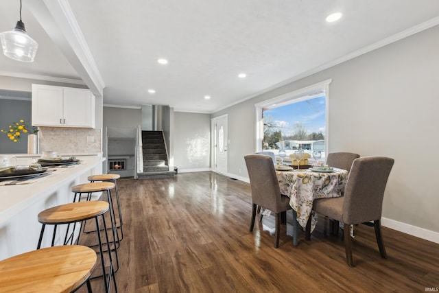 dining space featuring crown molding and dark wood-type flooring