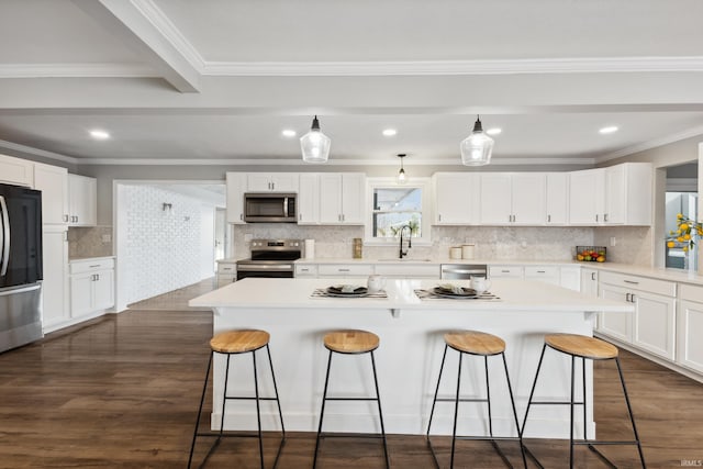 kitchen with sink, white cabinetry, dark hardwood / wood-style flooring, a kitchen island, and stainless steel appliances