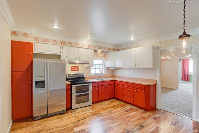 kitchen featuring appliances with stainless steel finishes, decorative light fixtures, white cabinetry, sink, and light hardwood / wood-style floors