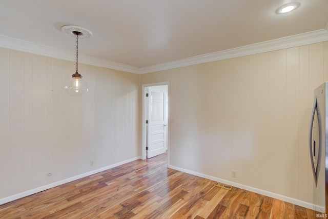 spare room with hardwood / wood-style flooring and crown molding