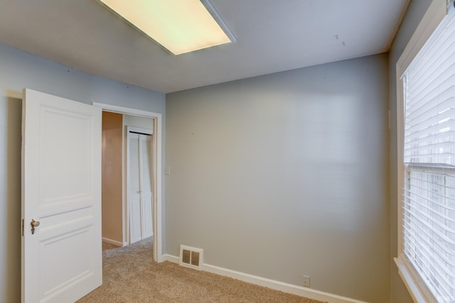 unfurnished bedroom featuring light carpet