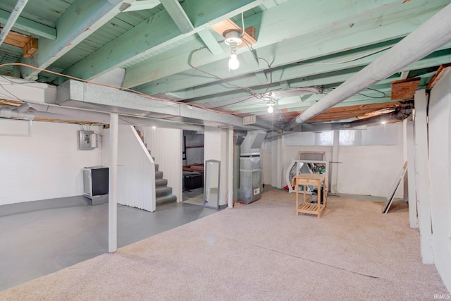 basement featuring electric panel and heating unit