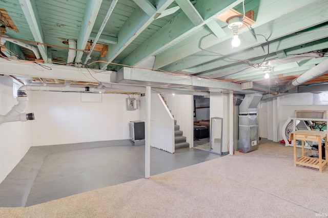 basement featuring heating unit and electric panel