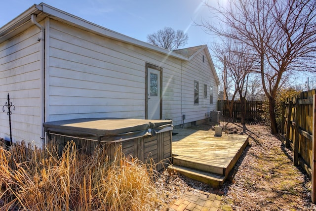 view of home's exterior featuring a hot tub, central AC, and a deck