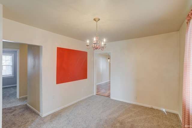 empty room with an inviting chandelier and carpet