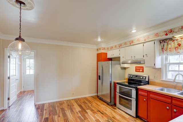 kitchen with sink, white cabinetry, decorative light fixtures, stainless steel appliances, and light hardwood / wood-style floors