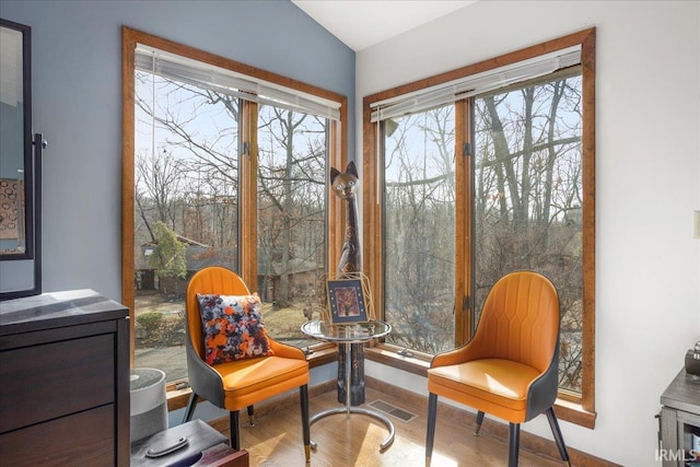 sitting room featuring hardwood / wood-style flooring, plenty of natural light, and vaulted ceiling