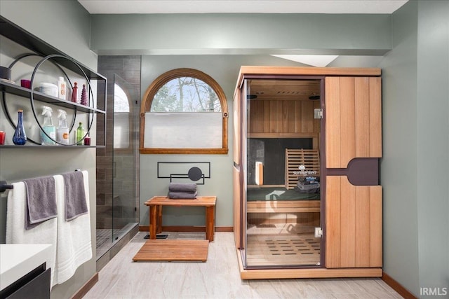 bathroom featuring hardwood / wood-style flooring, vanity, and a shower with door