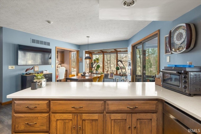 kitchen featuring decorative light fixtures, dishwasher, and a textured ceiling