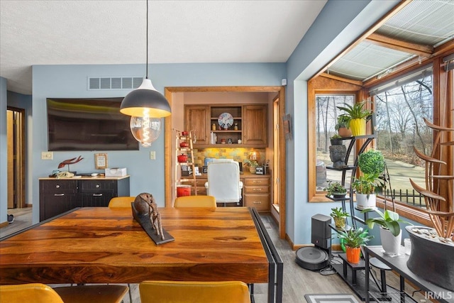 dining area featuring a textured ceiling and light hardwood / wood-style floors