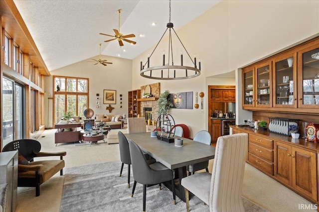 carpeted dining area with high vaulted ceiling, a textured ceiling, and a fireplace