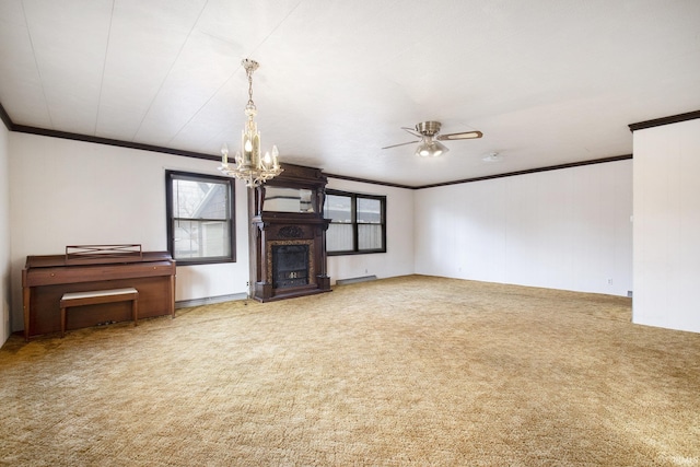 unfurnished living room featuring ceiling fan with notable chandelier, a wealth of natural light, ornamental molding, and carpet