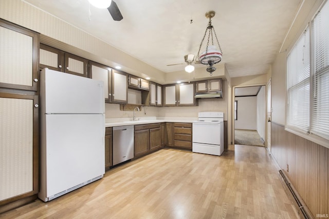 kitchen featuring a baseboard radiator, light hardwood / wood-style flooring, white appliances, and decorative light fixtures