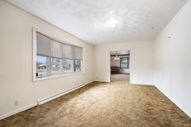 empty room featuring baseboard heating, carpet flooring, and a chandelier