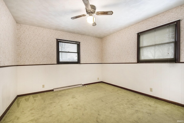 carpeted empty room featuring baseboard heating and ceiling fan