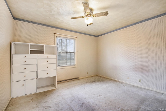 unfurnished bedroom featuring a baseboard heating unit, ornamental molding, light colored carpet, and ceiling fan