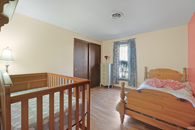 bedroom with hardwood / wood-style flooring and a closet