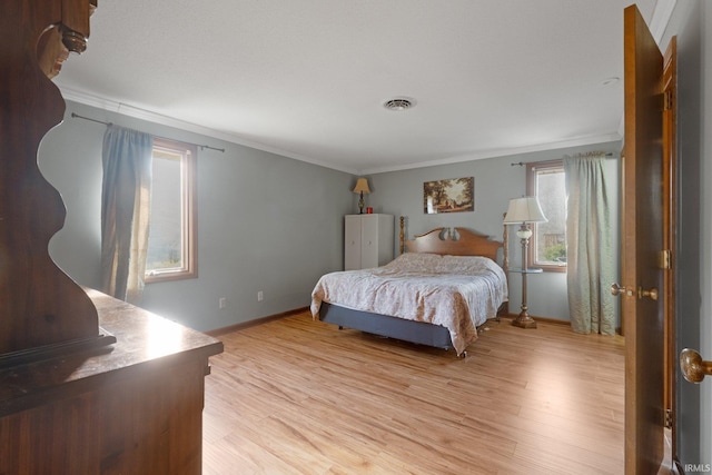 bedroom featuring ornamental molding and light hardwood / wood-style flooring