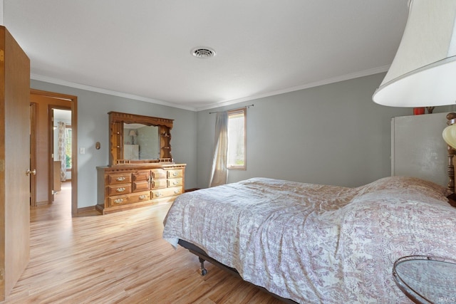 bedroom with crown molding and light wood-type flooring