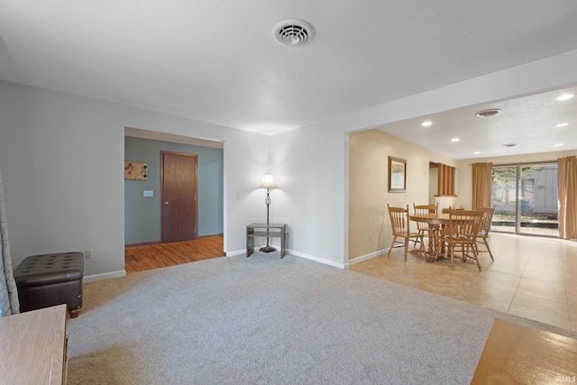 carpeted living room featuring a textured ceiling