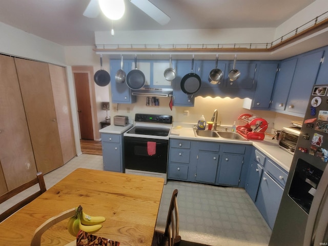 kitchen with electric stove, blue cabinets, and stainless steel fridge