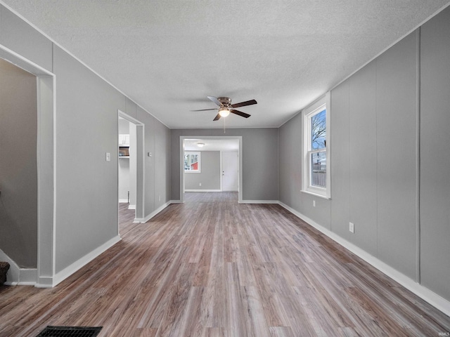 interior space with ceiling fan, a textured ceiling, and light hardwood / wood-style floors