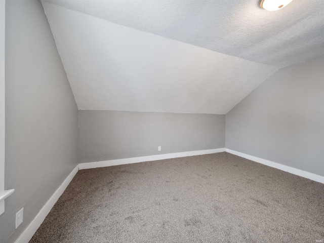 bonus room with lofted ceiling, carpet floors, and a textured ceiling