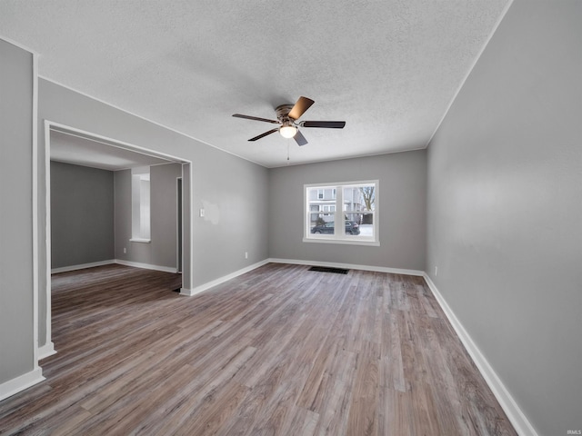 spare room featuring ceiling fan, hardwood / wood-style floors, and a textured ceiling