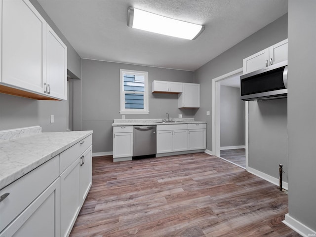 kitchen featuring stainless steel appliances, light hardwood / wood-style floors, sink, and white cabinets