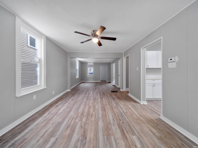 unfurnished living room featuring ceiling fan and light wood-type flooring