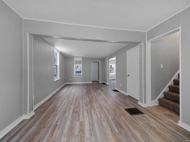 unfurnished living room featuring light hardwood / wood-style floors and a textured ceiling