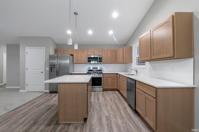 kitchen with a kitchen island, appliances with stainless steel finishes, pendant lighting, sink, and decorative backsplash