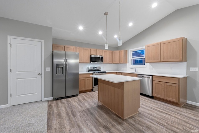 kitchen with a kitchen island, appliances with stainless steel finishes, lofted ceiling, sink, and hanging light fixtures