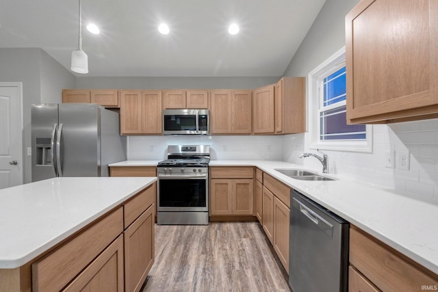 kitchen with pendant lighting, sink, stainless steel appliances, light brown cabinets, and light wood-type flooring