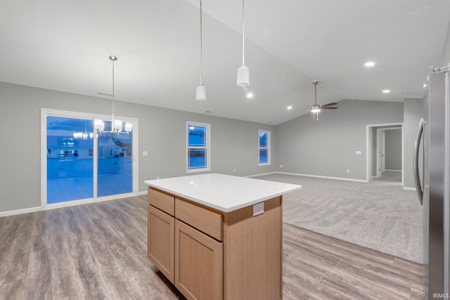 kitchen with ceiling fan, lofted ceiling, stainless steel fridge, and decorative light fixtures