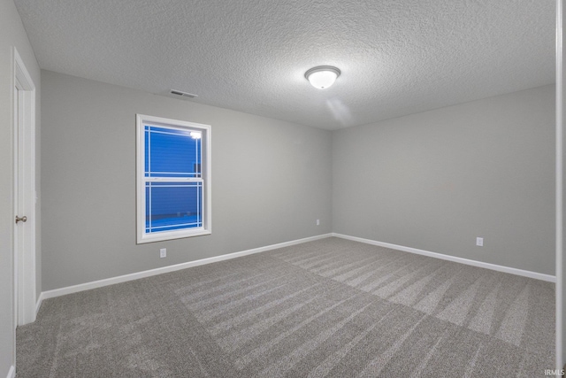 carpeted spare room with a textured ceiling